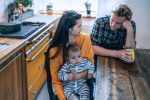 serious,family,with,baby,sitting,at,kitchen,table,at,home